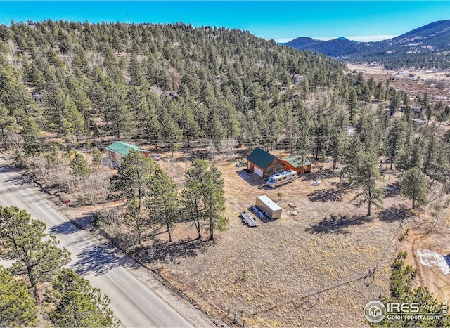 drone / aerial view with a wooded view and a mountain view