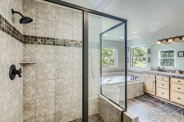 bathroom with vanity, shower with separate bathtub, and a textured ceiling