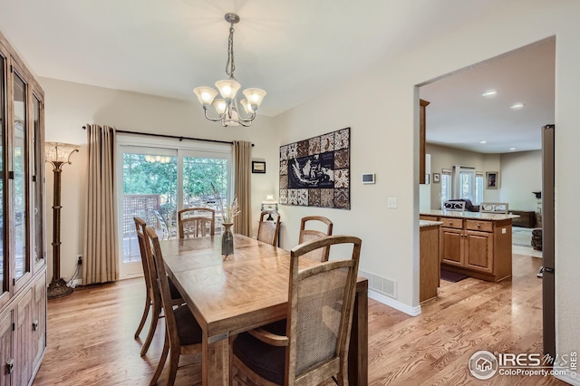 dining space with a chandelier and light wood-type flooring