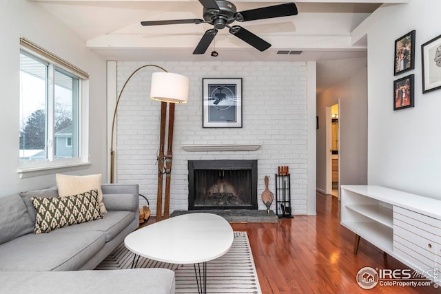 living room with dark wood-type flooring, ceiling fan, lofted ceiling, and a fireplace