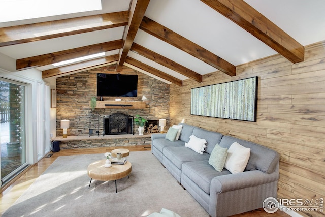 living area with a stone fireplace, lofted ceiling with beams, wooden walls, and wood finished floors