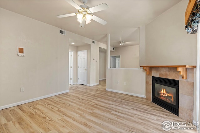 unfurnished living room with ceiling fan, a fireplace, and light hardwood / wood-style floors