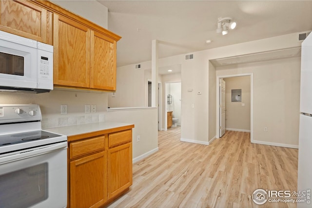 kitchen with white appliances, electric panel, and light hardwood / wood-style floors