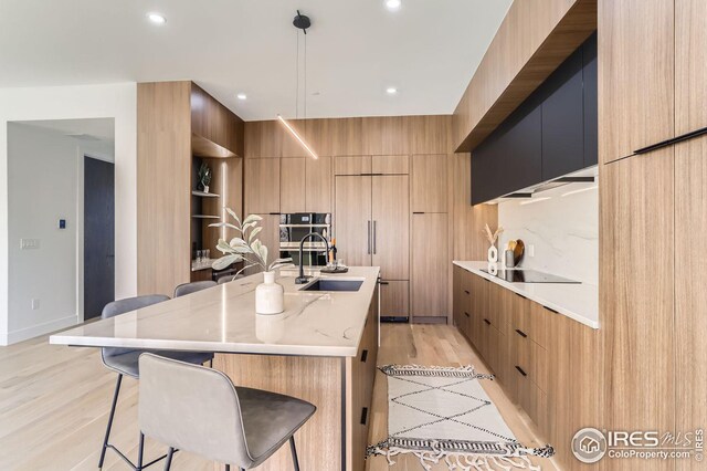 dining space featuring sink, a chandelier, and light hardwood / wood-style floors