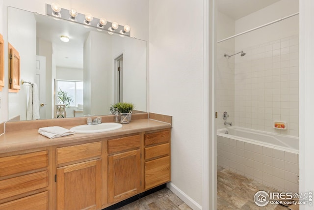 bathroom featuring tiled shower / bath and vanity
