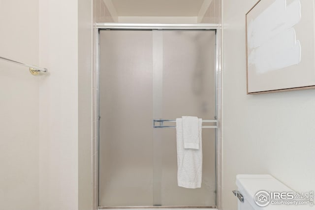 full bathroom with a tile shower and toilet