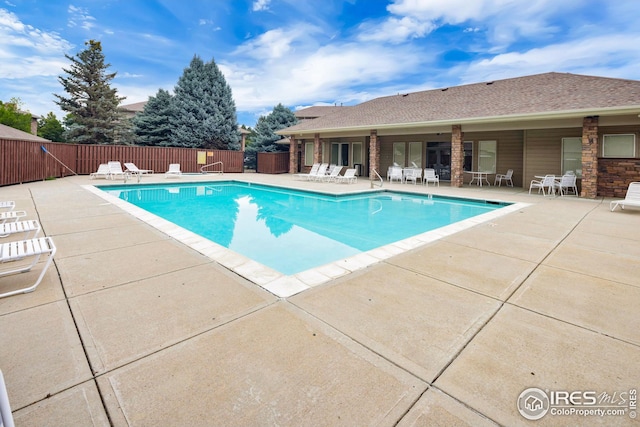 community pool featuring a patio area and fence