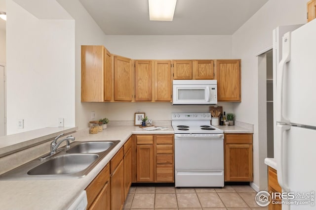 kitchen with white appliances, light countertops, a sink, and light tile patterned floors