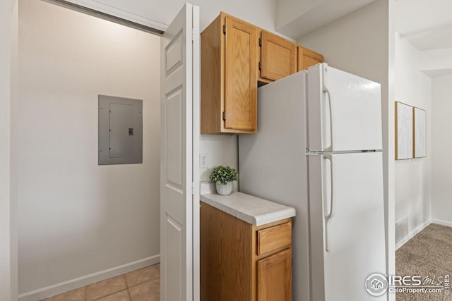 kitchen with freestanding refrigerator, electric panel, light countertops, and baseboards
