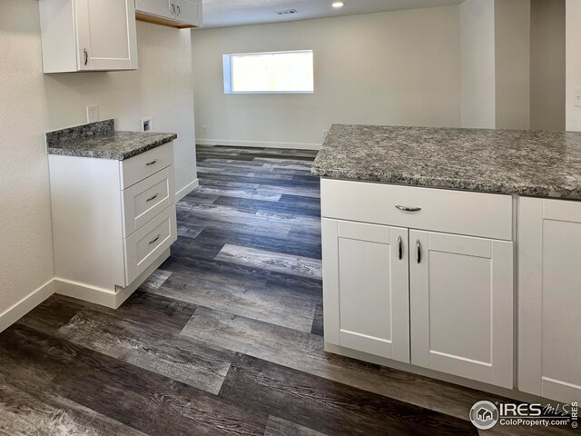 kitchen featuring dark wood-style floors, visible vents, white cabinetry, and baseboards