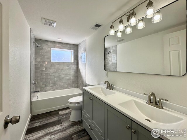 bathroom featuring visible vents, wood finished floors, and a sink