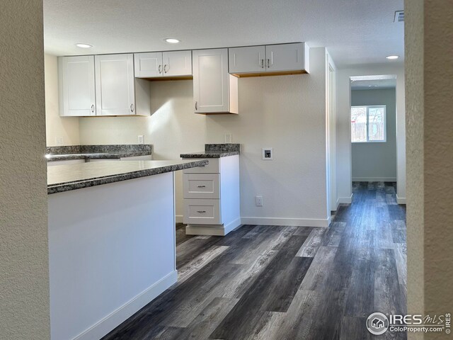 kitchen featuring visible vents, dark wood-type flooring, baseboards, recessed lighting, and white cabinetry