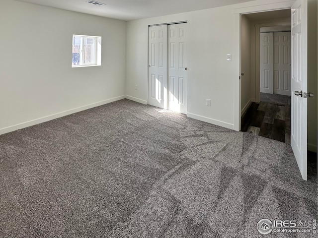 unfurnished bedroom with a closet, carpet flooring, baseboards, and visible vents