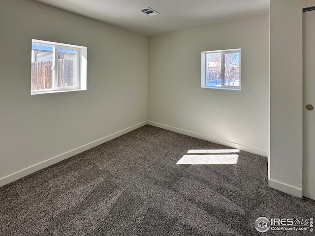 unfurnished room with visible vents, baseboards, and carpet flooring