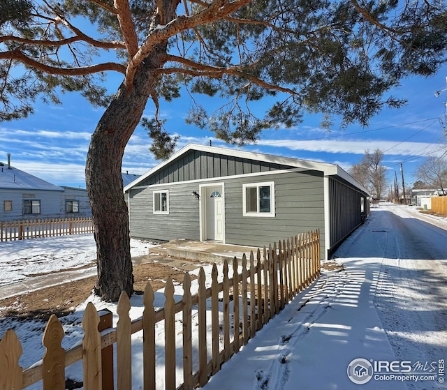 view of front of house with a fenced front yard and board and batten siding