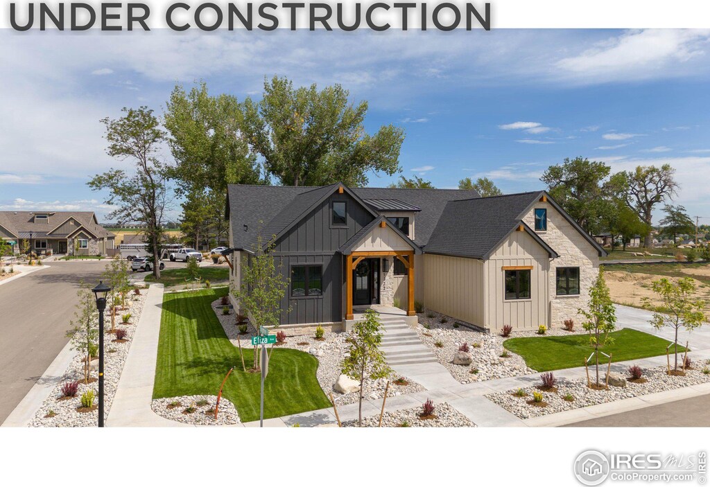 3806 Bridle Ridge Cir, Severance, CO 80524 - view of front facade with a garage, a front lawn, stone siding, stucco siding, and concrete driveway