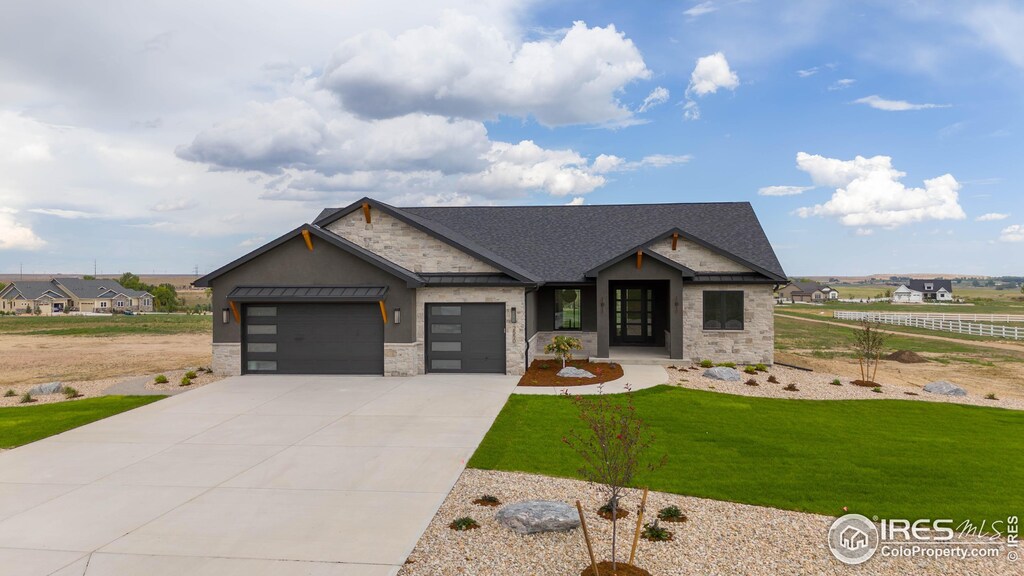 3806 Bridle Ridge Cir, Severance, CO 80524 - view of front of property featuring a front yard, a garage, concrete driveway, a shingled roof, and stone siding