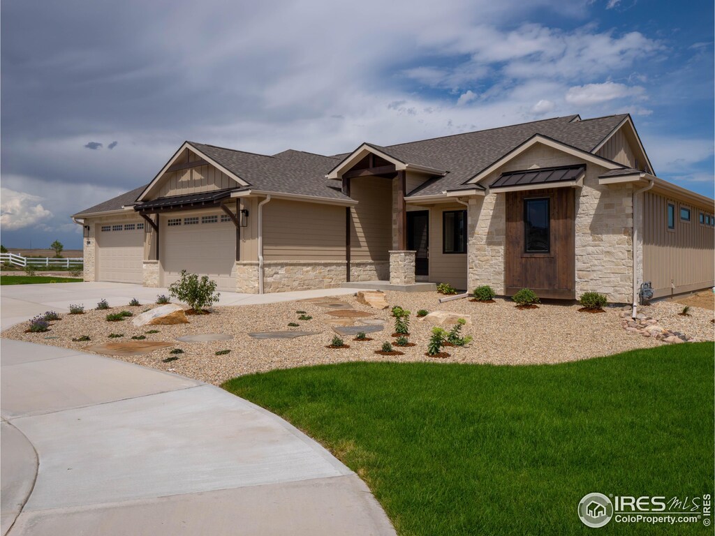 3806 Bridle Ridge Cir, Severance, CO 80524 - view of front of house with an attached garage, a chimney, a front yard, and stone siding
