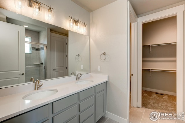 bathroom featuring tile patterned flooring, vanity, and walk in shower