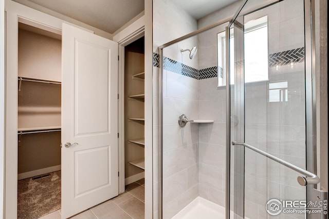 bathroom featuring tile patterned floors and a shower with door