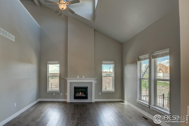 unfurnished living room with ceiling fan, high vaulted ceiling, wood-type flooring, and a wealth of natural light