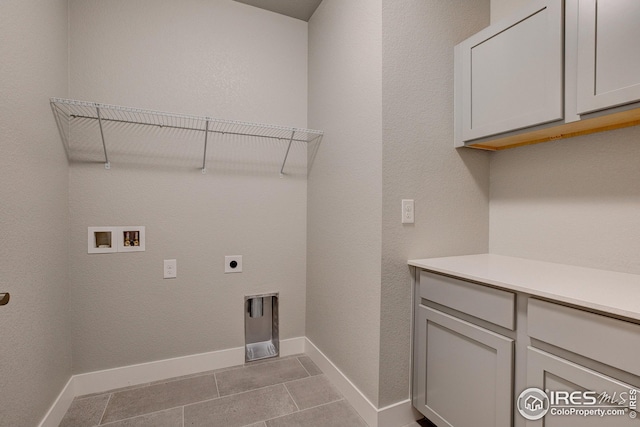 laundry area with cabinets, hookup for a washing machine, light tile patterned flooring, and electric dryer hookup