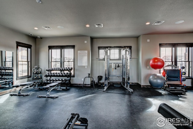 exercise room with plenty of natural light and a textured ceiling