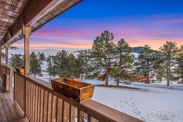 snow covered deck with a mountain view