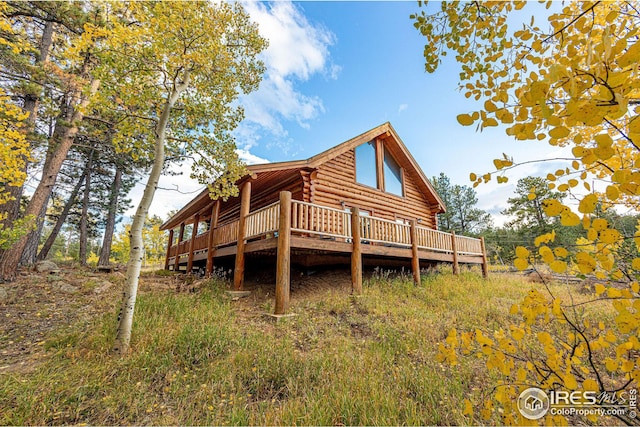 rear view of property with log exterior and a deck