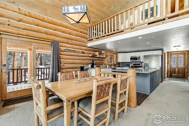 dining area with rustic walls, a towering ceiling, wood ceiling, and recessed lighting