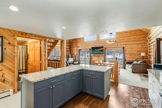 kitchen with log walls, dark wood-style floors, open floor plan, a center island, and a baseboard heating unit