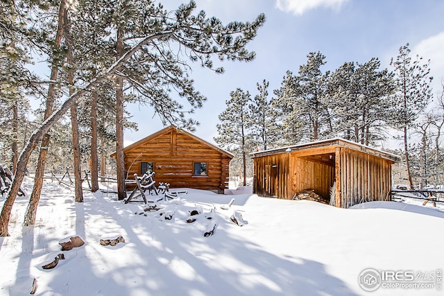 yard layered in snow featuring an outbuilding
