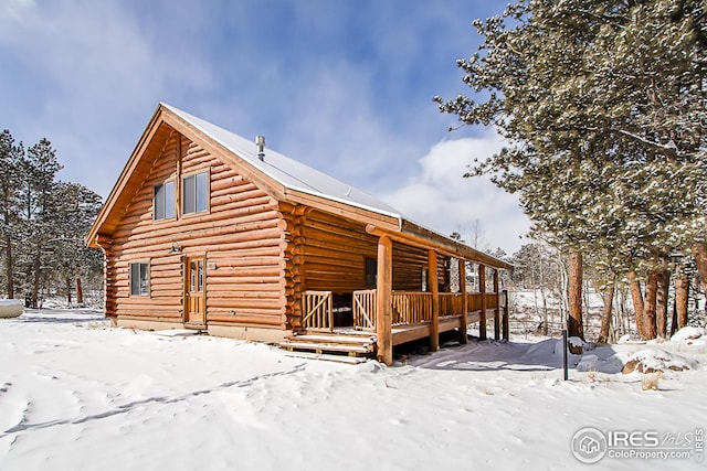 view of snow covered exterior with log exterior
