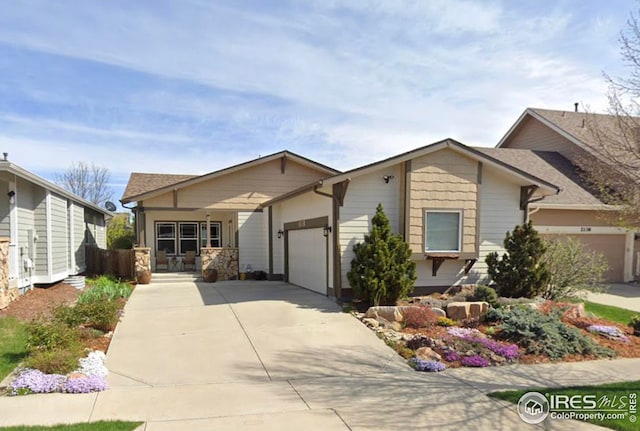 view of front of home with a garage, driveway, a porch, and fence