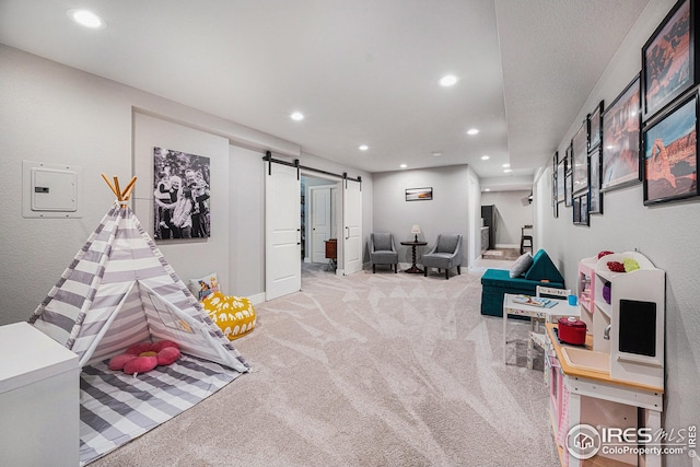 recreation room with recessed lighting, light colored carpet, baseboards, and a barn door