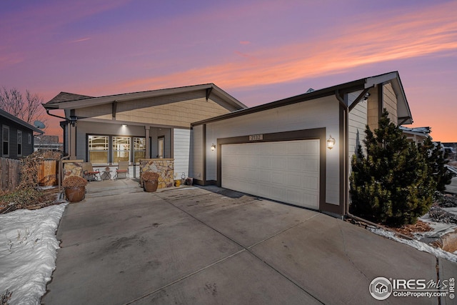 view of front of property with a garage, concrete driveway, and covered porch