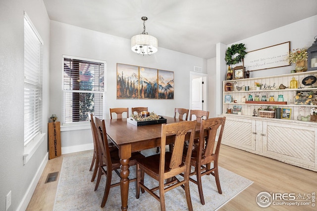 kitchen featuring light wood-style flooring, appliances with stainless steel finishes, a sink, dark brown cabinets, and backsplash