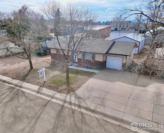 view of front of property featuring brick siding, an attached garage, a shingled roof, and concrete driveway