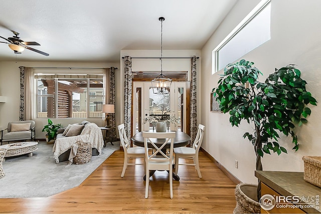 dining space featuring light wood-style flooring, baseboards, and a wealth of natural light