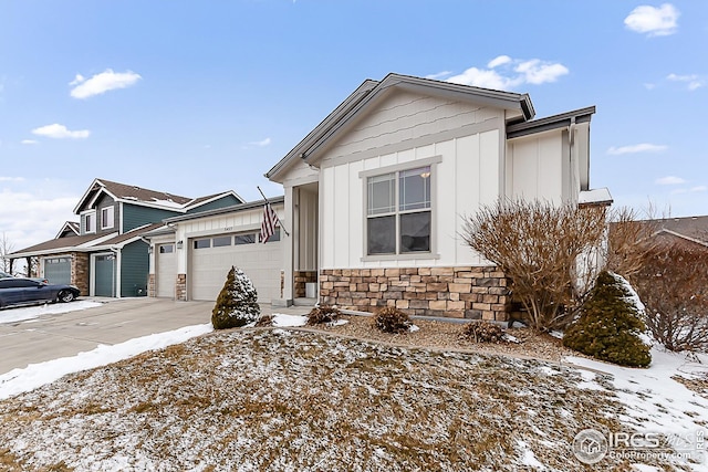 view of front of house with concrete driveway, stone siding, board and batten siding, and a garage