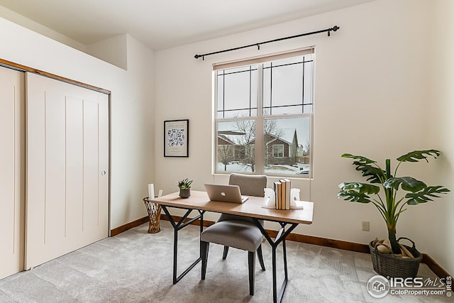 office featuring baseboards and light carpet