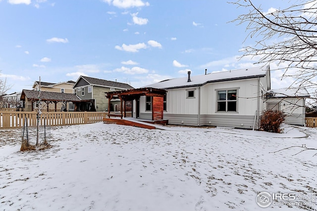 view of snow covered back of property