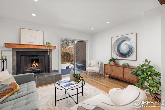 living area featuring recessed lighting, baseboards, wood finished floors, and a fireplace