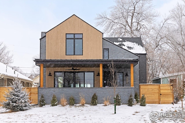 view of front of property with a porch, fence, brick siding, and a ceiling fan