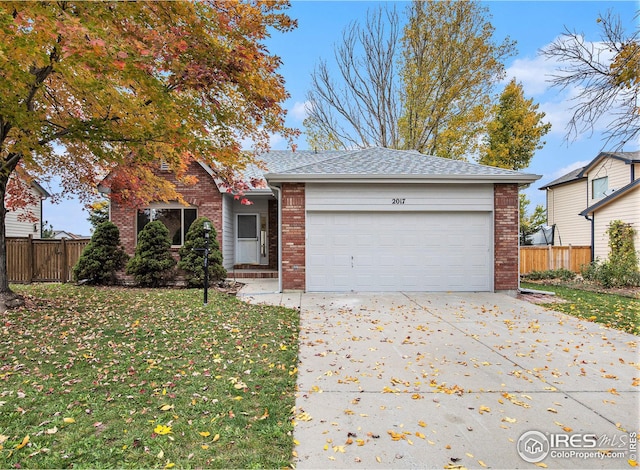 ranch-style home featuring a front yard, fence, and an attached garage