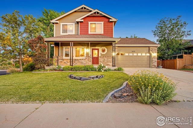 craftsman house with a garage, driveway, brick siding, and a front lawn