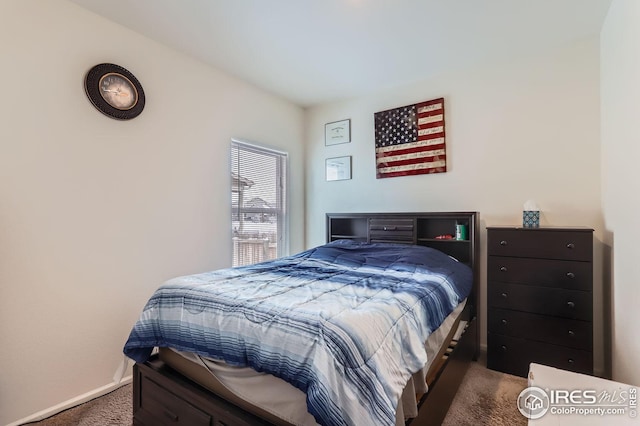 bedroom featuring dark colored carpet and baseboards