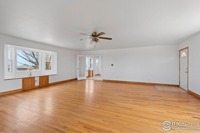24525 County Road 53, Kersey, CO 80644 - unfurnished living room featuring a ceiling fan, light wood-type flooring, and baseboards