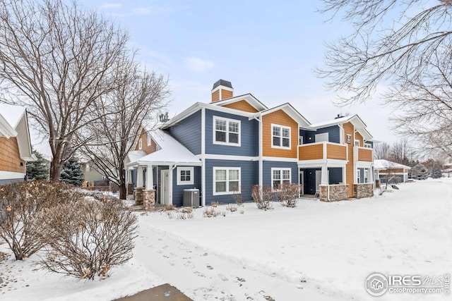 snow covered house with central AC