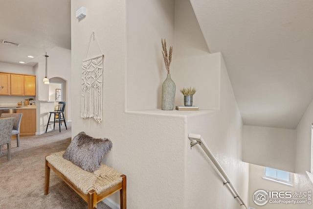 interior space featuring visible vents, arched walkways, light colored carpet, an upstairs landing, and recessed lighting